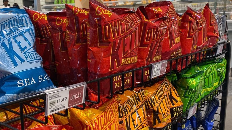 Multiple bags and colors of Low Country Kettle chips on store rack