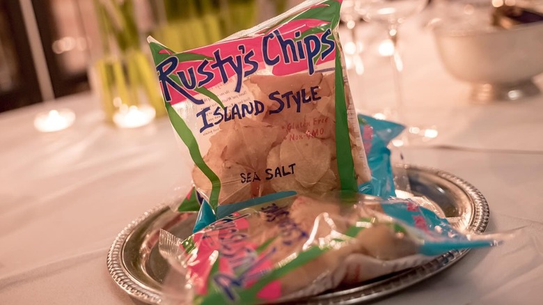 small, clear bags of Rusty's Island Style chips on silver plastic plate on white table cloth