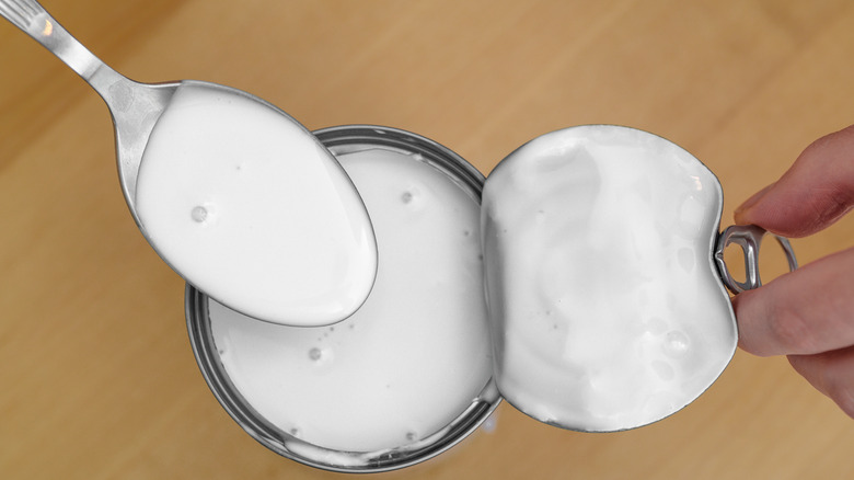 overhead shot opened can coconut milk with spoon