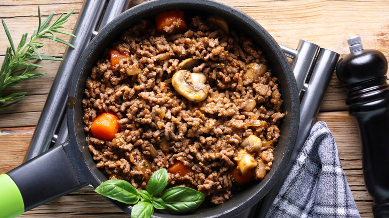 Ground beef in a pan with sliced mushrooms and other vegetables