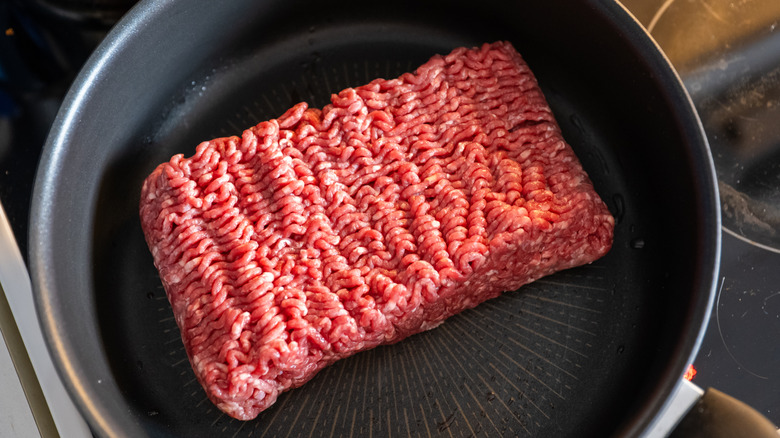 Block of raw ground beef in a pan