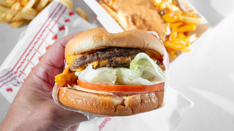 Hand holding In-N-Out double double burger