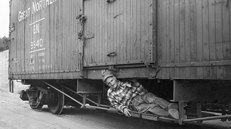 A man laying under a train in 1950