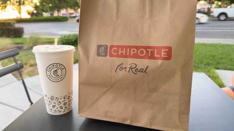 A Chipotle to-go order on a table outside