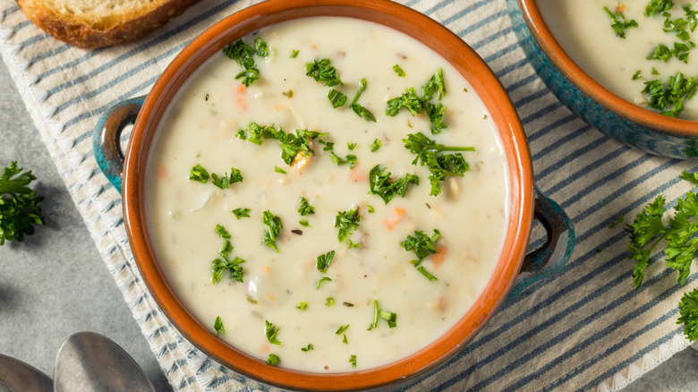 Creamy clam chowder soup with bread and parsley