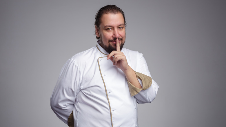 Chef keeps a secret about the ingredients. The index finger to his lips.