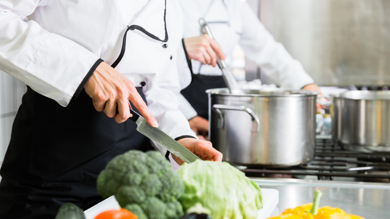Team of chefs preparing food in canteen kitchen