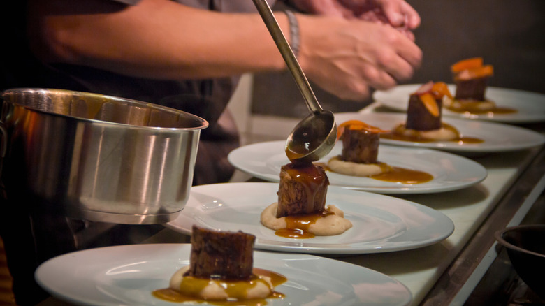Chef plating food at a fine dining restaurant, motion close-up.
