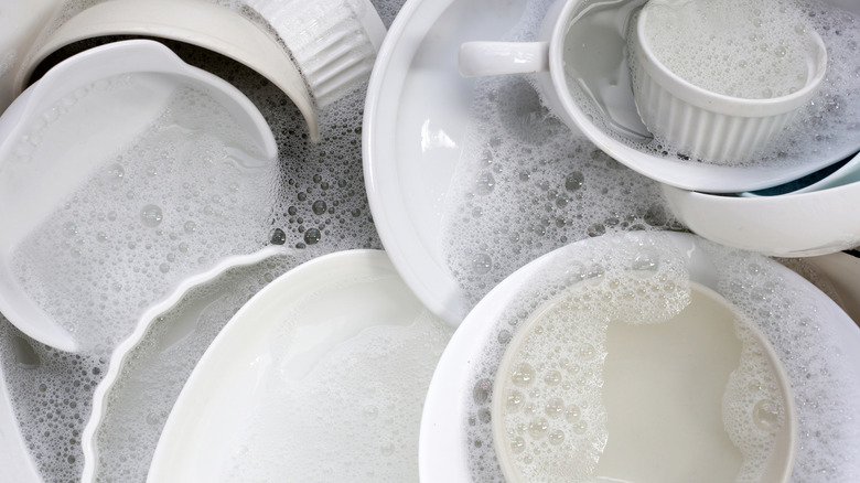 Dishes soaking in soapy water.
