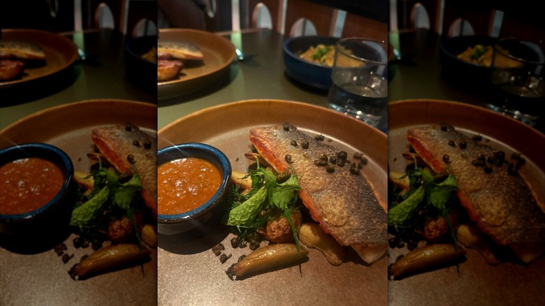 Fish and sauce on brown plate
