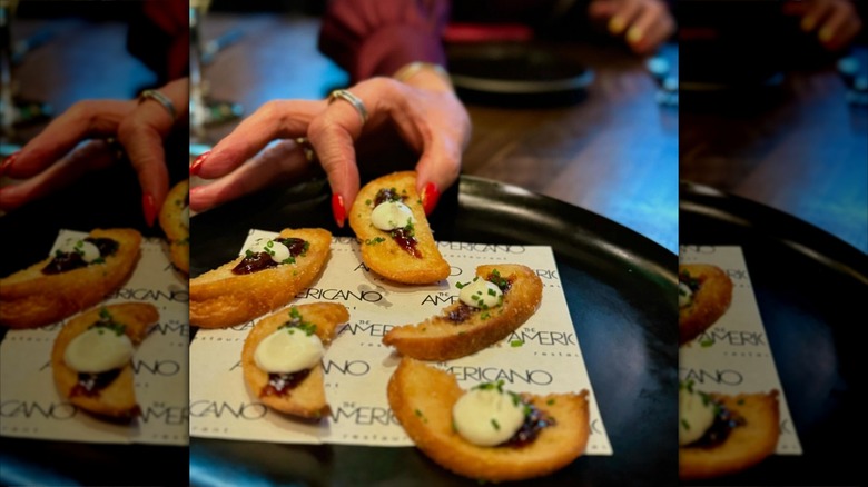 Hand grabbing appetizer from plate