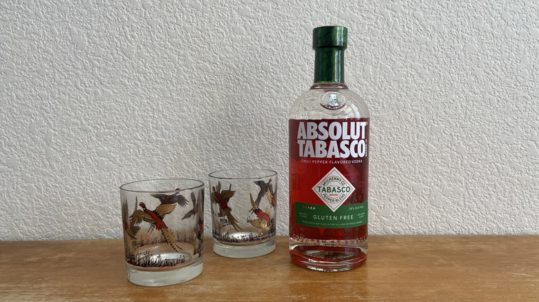 Absolut Tabasco bottle beside two glasses with bird patterns