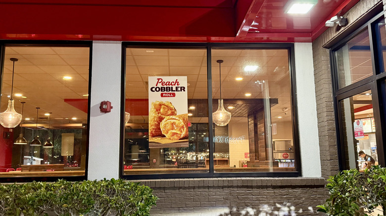 Peach cobbler ad on Arby's window in empty dining room seen from outside restaurant