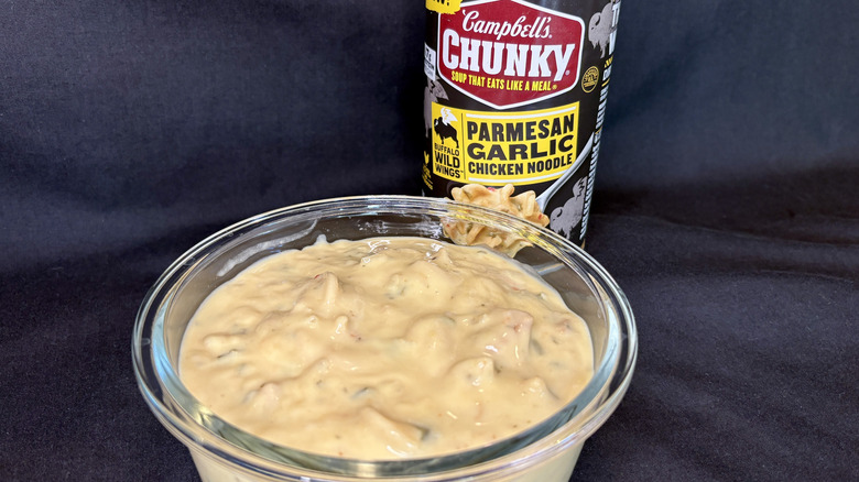 Bowl of soup in front of can of Campbell's Buffalo Wild Wings Chunky Parmesan Garlic Chicken Noodle Soup