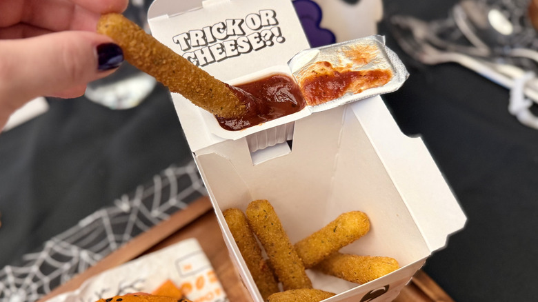 Dipping a Mummy Mozzarella Fry into marinara sauce