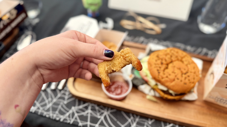 Holding a Vampire Nugget dipped in ketchup