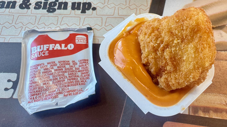 A nugget dipped in an orange Buffalo Sauce.