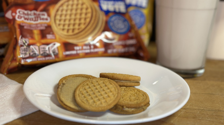Close up of Oreo Chicken & Waffles cookies on a white plate with package in background and glass of milk