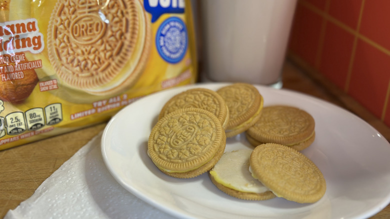 Oreo Banana Pudding Cookies on a white plate with packaging and glass of milk in the background