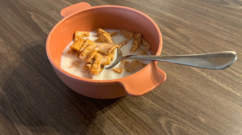 Cinnamon Toast Crunch Mega Chamoy-Flavored Cereal in an orange bowl with milk and a spoon