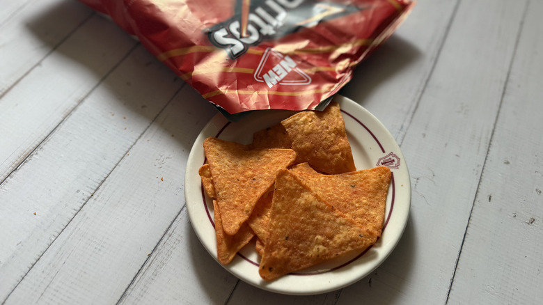 a bag opened onto a plate of Doritos Protein -- Nacho Cheese