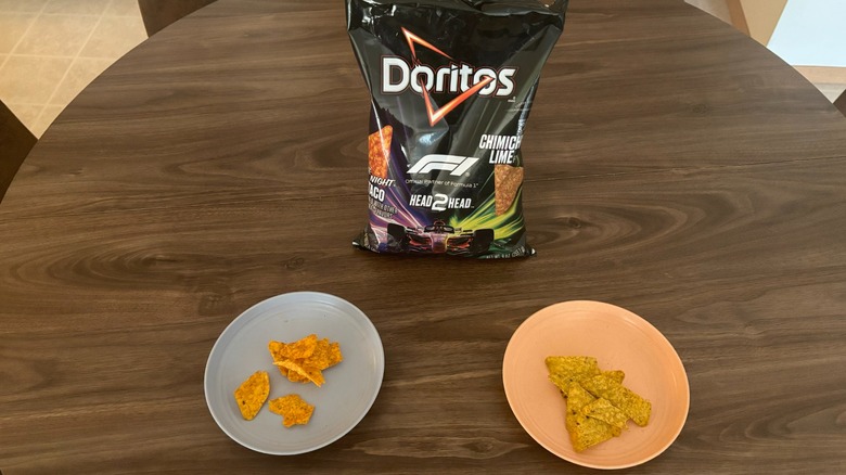 Bag of Doritos F1 Head2Head chips on table in between two plates with different flavors of the chips, including Late Night Loaded Taco and Chimichurri Lime