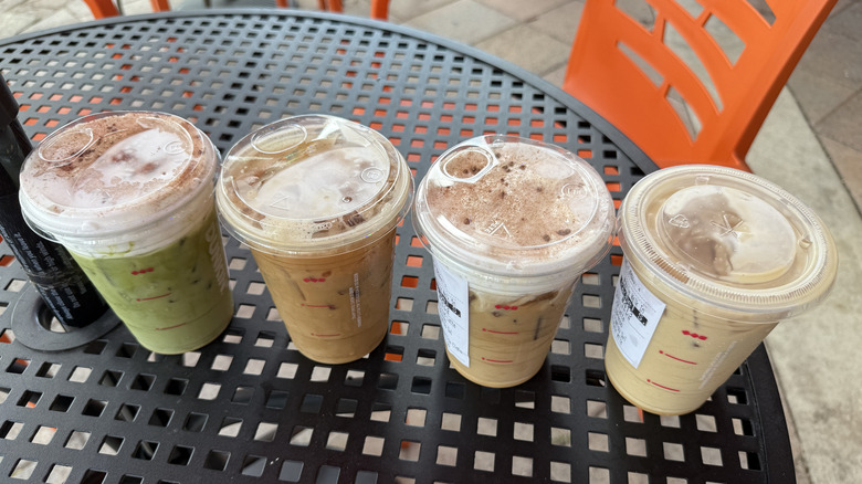 Four Dunkin' tiramisu cold beverages in takeout cups on a metal table