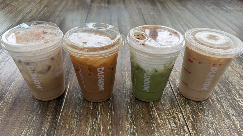Four Dunkin' tiramisu drinks on a wooden table