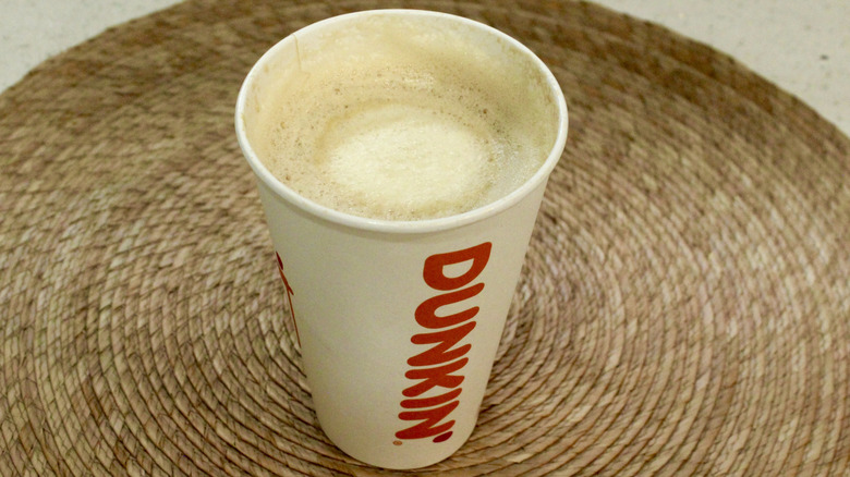 Dunkin' latte with froth on placemat