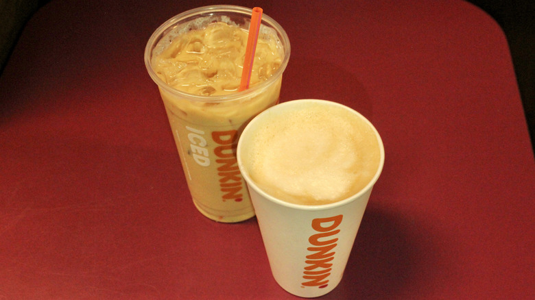 Iced and hot lattes from Dunkin' on pink table