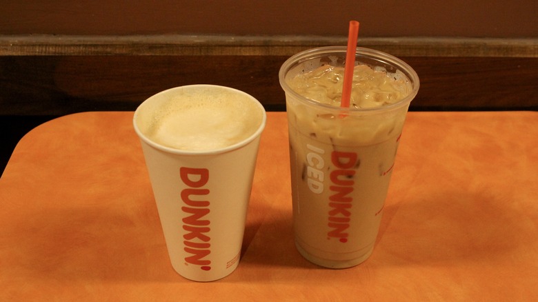 Hot and iced lattes from Dunkin' on orange table