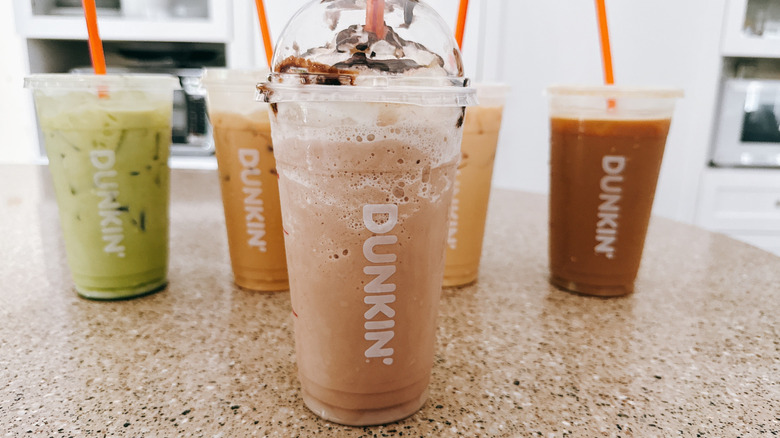 A variety of Dunkin' iced beverages on a granite counter