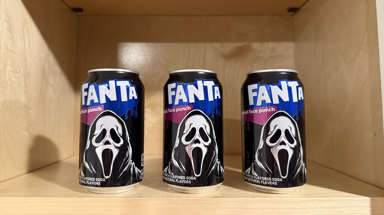 three cans of Fanta Ghost Face Punch on a shelf