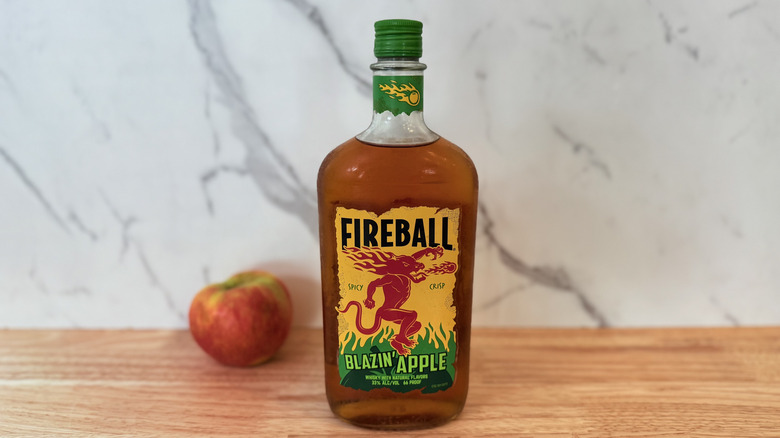 Bottle of Fireball Blazin' Apple with apple in background