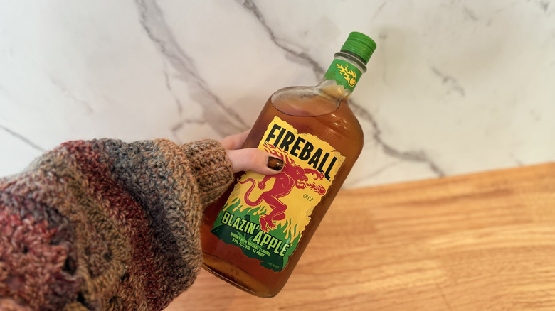 Holding bottle of Blazin' Apple