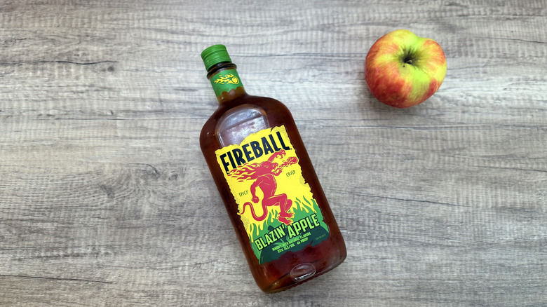Bottle of Fireball Blazin' Apple laying on wood table