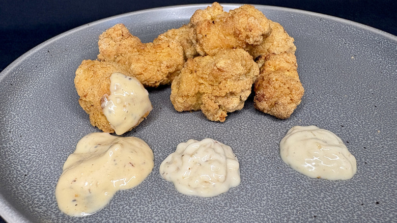 chicken nuggets dipped into sauce on plate