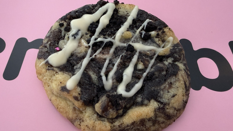 Crumbl Cookies & Cream White Chip Cookie on top of a pink Crumbl box