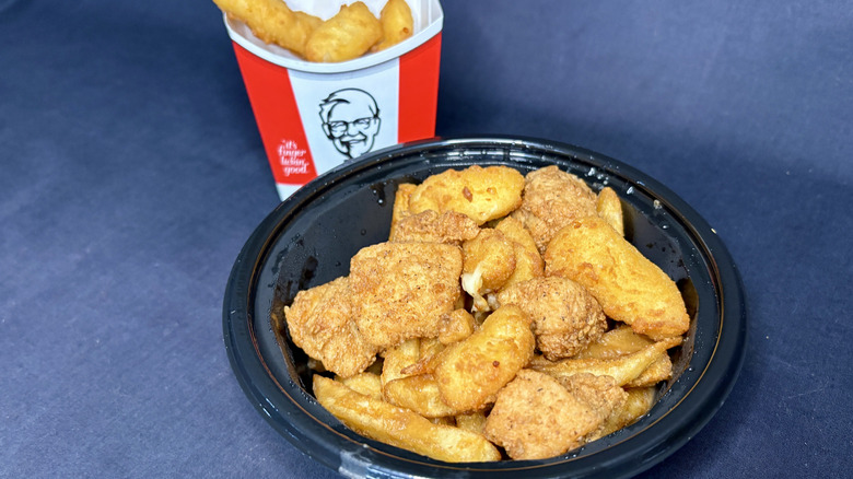 KFC bowl with chicken and fries in front of KFC cheese curds in cardboard sleeve holder