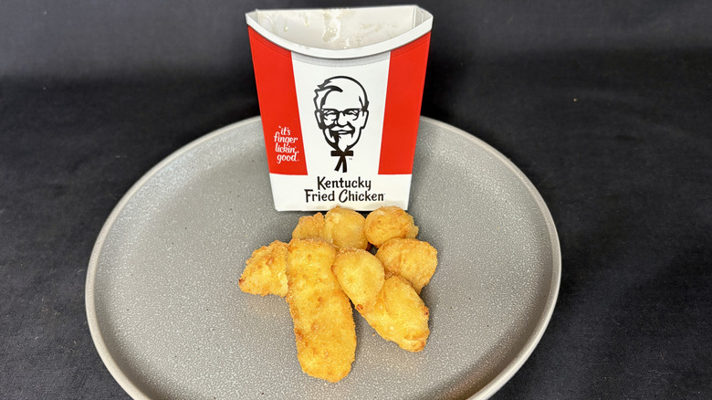 KFC cheese curds with cardboard sleeve holder on plate