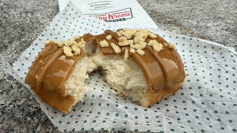 Doughnut broken in half to show cheesecake filling on inside