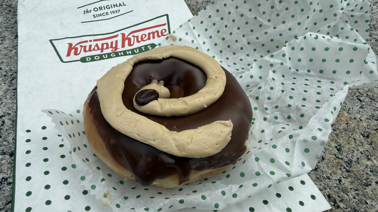 Café Mocha doughnut topped with chocolate icing, swirl of coffee-flavored buttercream, and mocha bean
