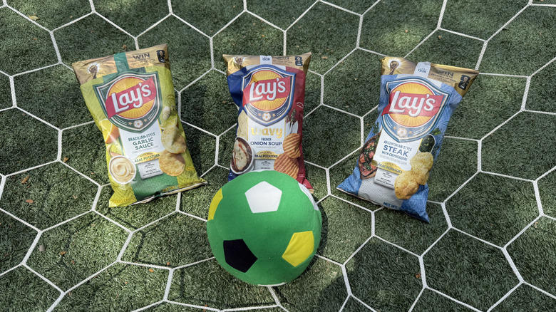 Three bags of Lay's World Cup Globally Inspired Flavors on a net with a soccer ball