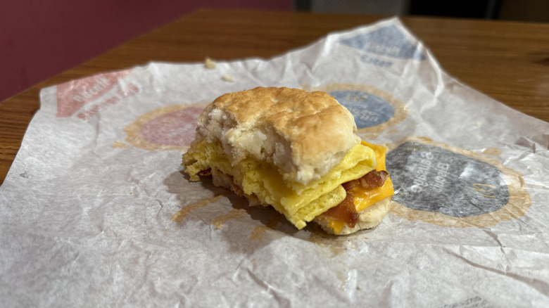 a bitten Honey Brown Butter Bacon Egg Cheese Biscuit