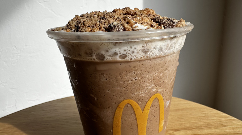 Close up of McDonald's Chips Ahoy! Frappe with cookies sprinkled on top on wooden table