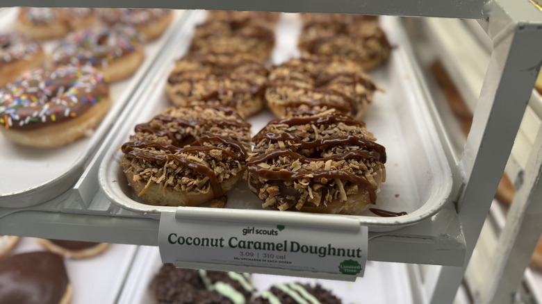Krispy Kreme Coconut Caramel Doughnuts on a tray in a display case