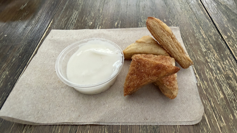 Panera Cinnamon Croissant Bites with side of icing on wooden table