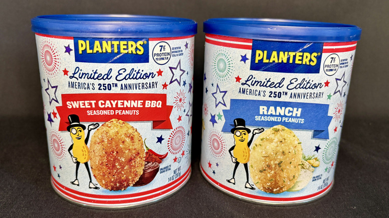 Two cans of Planters peanuts on a gray background
