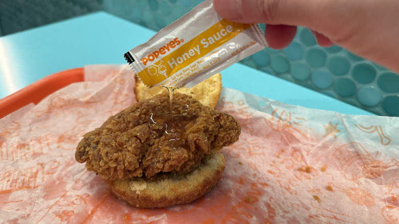 dripping honey sauce on a Honey Chicken Biscuit