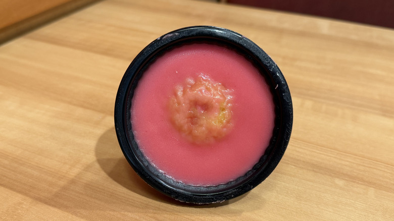 Popeyes' Cupcake Cup lying sideways in its container on a wood table